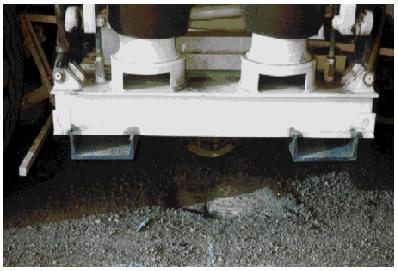 Closeup of the vibrator frame of the Vibroseis truck. This image shows a closeup view of the Vibroseis truck vibrator frame above the pavement.