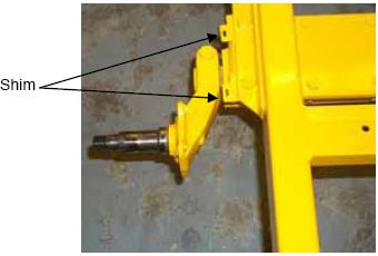Photograph shows the top view of a torsion axle and shims. Arrows indicate the locations of the two shims.