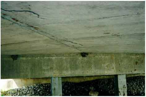 Figure 28. Photo. Cracking, rust staining, and spalling on the soffit of the bridge. The photograph shows cracking, rust staining, and spalling on the soffit of the bridge deck carrying SR-295 over Blue Creek in Lucas County, OH, during the third evaluation.