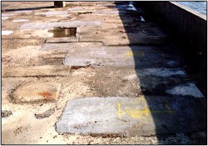 Photo B shows about six irregular patched areas of varying sizes on the pontoon deck, between the pillars and the edge. 