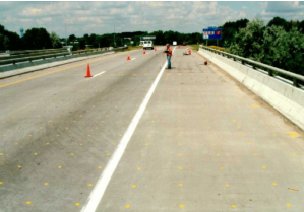 Photo B shows the bridge deck, with two lanes, a breakdown lane, and a shoulder on the opposite side. There are guardrails on both sides of the bridge deck.