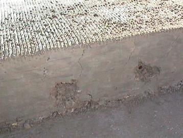 Figure 18.  Photo.  Plastic shrinkage cracking in concrete pavement.  The hairline cracks running from the top of the slab downward are the plastic shrinkage crack.