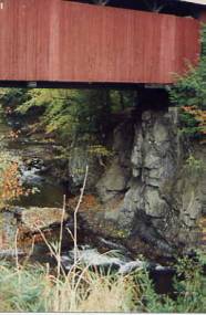 The closeup of one end of the bridge shows it set on a natural rock feature that will outlast the bridge itself. Many bridges use natural formations for support.