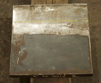 The photo shows a plan view of HSS procedural test plate TP2 with the weld oriented horizontally. The specimen is comprised of plates of equal thickness and width.
