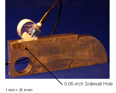 Figure 23. Photo. Resolution check: Photograph shows that the selected angle transducer is positioned on the IIW type RC reference block over the line indicative of the transducer angle.
