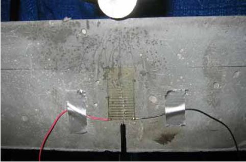 Prism M2P03 after 93 millimeters (3.63 inches) of crack extension. This photo shows cracks having extended up the face of a prism until they reach 93 millimeters from the bottom of the prism. Multiple cracks are visible all progressing toward the load point.