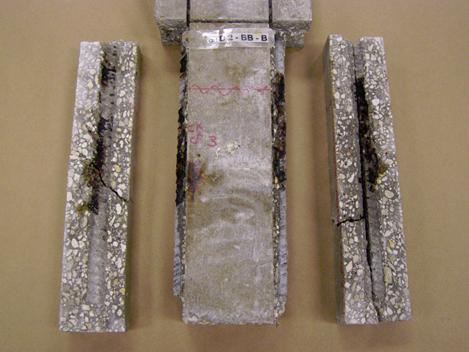 Figure 114. Photo. Specimen 3BTC-STD2-BB-B after sectioning and opening along the two longer bars. This is a photograph of specimen 3BTC-STD2-BB-B after sectioning and opening along the two longer bars. Corrosion is apparent on the bars and bar traces at mid specimen height.