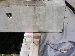 This photo illustrates placement of the concrete box on the geosynthetic reinforced soil (GRS) abutment bearing seat. The picture is a close-up to show the 8-inch setback created with the foam board and solid 4-inch concrete block.