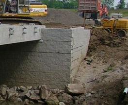 This photo illustrates how the beams ends are embedded into the geosynthetic reinforced soil (GRS) abutment. The photo shows the parapet wing walls up against the side of the beams with several additional layers of GRS, depending on the thickness of the bridge girders.