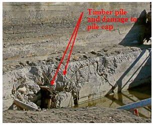 Photo. Close-up of exposed pile and pile cap damage on south abutment of Tubul bridge. Click here for more information.