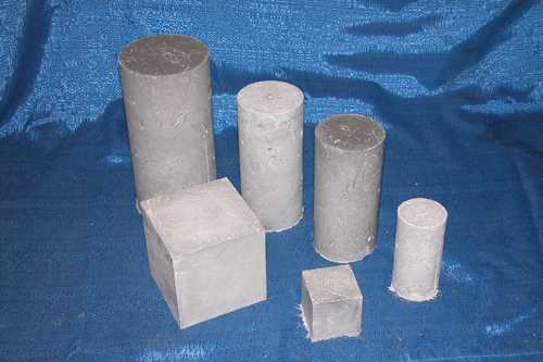 This photo shows six different sizes of compression test specimens that can be used in the determination of ultra-high performance concrete (UHPC) compressive strength. The photograph includes four sizes of cylinder and two sizes of cube.