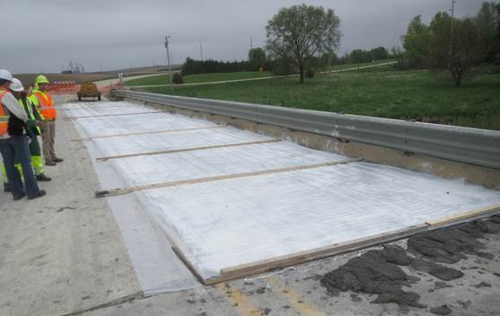 Figure 20. This figure is a photo after the UHPC overlay has been installed on the westbound lane. The entire lane is covered with plastic sheeting. Plastic sheeting prevents moisture loss during UHPC curing.