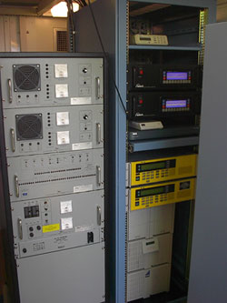 Figure 1.  Hagerstown-The HA-NDGPS Broadcast Station Rack 
Photo.  This photograph shows two equipment racks.  The one on the left holds the NDGPS 1-kilowatt transmitter.  The equipment rack on the left contains the dual GPS receivers, the dual integrity monitors, the uninterruptible power supply, and the modulator computer running the HA-NDGPS data compression program and the modulator programs.