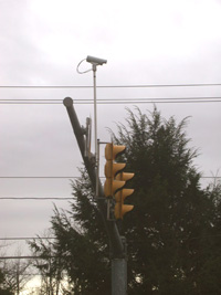 Traffic signal with a traffic detector mounted on the signal arm.