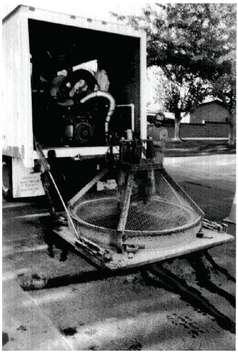 Figure 5–39. Roadway installation of round loops – cutting loop circle. Photograph of round saw in place over pavement surface being cut. 