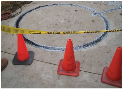Figure 5-52. Isolation of affected area to allow sealant to dry. Fluorescent orange traffic cones and yellow caution tape are used to close off the loop area until the sealant fully dries.