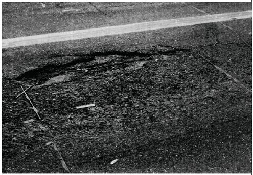 Figure 6-1. Pavement failure near an inductive loop installation. Photograph showing pavement failure along the sawcut that exposes the wire loops. 