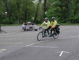 Figure 45: Photo. Two tandem riders negotiating a curve at the turning radius station. Two participants on one tandem are negotiating a curve at the turning radius station.
