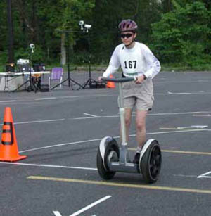 Figure 52: Photo. Segway in the turning radius station. A participant on a Segway is maneuvering through the turning paths created in a parking lot.