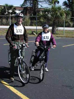 Figure 54: Photo. Two "Ride for Science" participants. Two older participants on bicycles are standing in the parking lot.