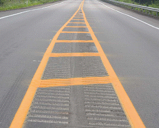 This figure shows an implementation of concept 1 at site 4 in Pennsylvania. This photo focuses on the painted median and median rumble strips. In this example, a painted median is installed with cross-hatching. Double rumble strips are installed in the median at a width of approximately 4.06 m (16 inches) wide which almost cover the full width of the median at the widest point. 
