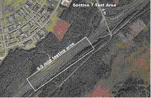 Figure 25.  Photograph.  Test section 7.  An aerial photograph illustrates the location of test section 7 on the Glenn Highway State Route 1 outside Anchorage, AK.  The testing area is located on a straight section of the highway.  There is an interchange with D Street approximately 0.1 mi beyond the test section at the top of the photograph.  The test section is approximately 0.5 mi long.