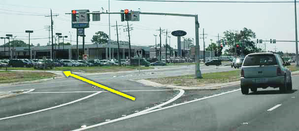The photo has a direction arrow identifying a driveway location at a displaced left-turn (DLT) intersection in Baton Rouge, LA.