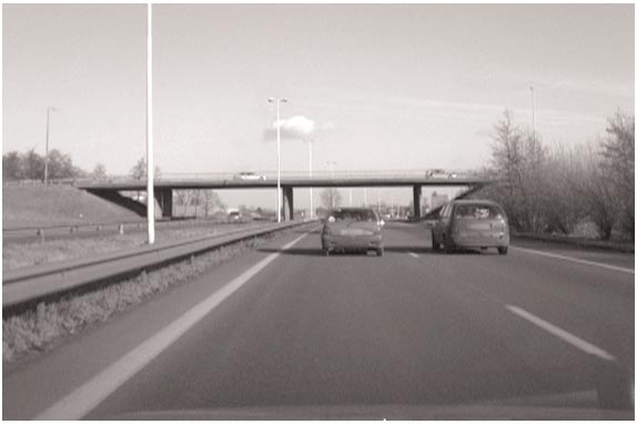 This photo shows two vehicles side-by-side on a two-lane highway.