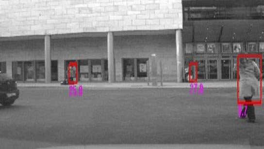 This photo shows several pedestrians close to buildings. They are detected by the appearance classifier, as seen by red bounding boxes.