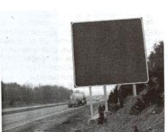 This photo shows a guide sign on the side of a highway without any information on it.