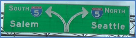 This photo shows a guide sign associated with scenario 2 critical point 2. It depicts a four-lane single direction highway that splits to the left and right with two lanes each; the middle lane is an option lane. The left split is labeled  5 South Salem,  and the right split is labeled  5 North Seattle. 