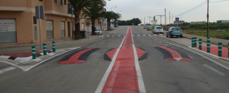 Figure 143. Photo. Speed kidney. This figure shows an example of a speed kidney. A speed kidney is a longitudinal speed bump that takes the shape of a kidney that lowers vehicle speeds by forcing the driver to choose one of two slow vehicle paths. The design consists of a curved speed bump in the middle-right of the travel lane and is complemented by an oval speed bump with the centerline as the long axis. This design forces the driver to take one of two vehicle trajectories. One is to continue in a straight line, causing lower speeds through mounting the speed bump with either one or two wheels. The other is following the curved path to avoid mounting the bump. This curved path leads to lower speeds as well.