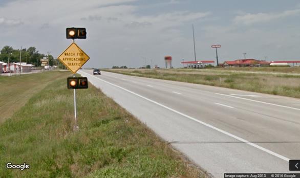 Figure 12. Photo. Minor route static sign with flashing beacons from Google Street ViewTM. This photograph shows a post-mounted warning sign stating "WATCH FOR APPROACHING TRAFFIC" with four flashing beacons.