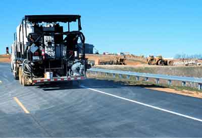 Photo. Application of the liquid system pavement marking. Click here for more detail.