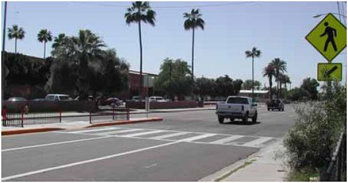 This median refuge island provides railing and a staggered crossing area to direct pedestrian views toward oncoming traffic.