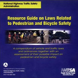 The photograph shows a CD-ROM entitled “Resource Guide on Laws Related to Pedestrian and Bicycle Safety.” The DOT and NHTSA logo are seen on the front of the CD-ROM.
