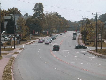 Figure 3. Photo. MLK in the before period. The photo shows Martin Luther King, Jr. Boulevard (MLK) in Chapel Hill, NC, in the before sharrow condition. There are four travel lanes, two in each direction, and a center two-way, left turn lane and a 3 to 4 percent grade. The photo also shows a seam, indicating that the old gutter area was paved over with asphalt. The outside lanes are approximately 15 ft wide.