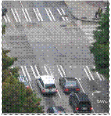 This photograph shows an aerial view of bar pairs markings near an intersection. The markings consist of several sets of two parallel, white vertical bars across the width of the street.