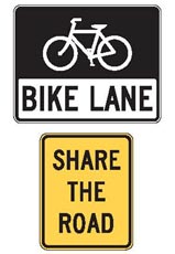 Two signs from the Manual on Uniform Traffic Control Devices (MUTCD) are pictured. The top sign is a bike lane sign, with a white bike icon on a black background above black words “BIKE LANE” on a white background. The bottom sign is yellow with “SHARE THE ROAD” in black.