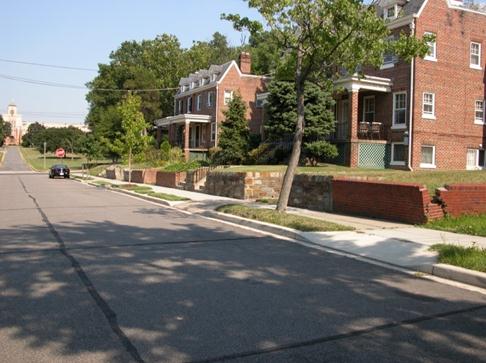 Figure 9. Photo. Example of a location with driveways/alleys. This photo shows the right-hand side of a street in a residential area with a motor vehicle parked along the curb. There are houses with driveways that connect to the street. Sidewalks and trees also line the street.