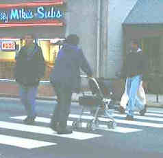The proposed revisions to crosswalk walking speeds may also benfit people who are not elderly, such as this pedestrian pushing 
		a stroller.