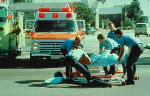 Picture of Emergency Medical Personnel attending an accident victim.