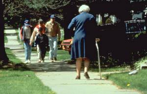 Picture of elderly woman walking on sidewalk.