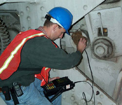 Inspector checking a steel bridge pin with ultrasonic technology