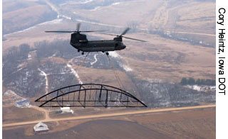 An Iowa Army National Guard helicopter is shown transporting part of the historic Hale Bridge to its new location.