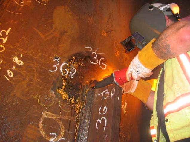 Figure 10: Grinding by MTE inspector Mike Virgillio to investigate magnetic particle indications at tab removal sites at location 3G.