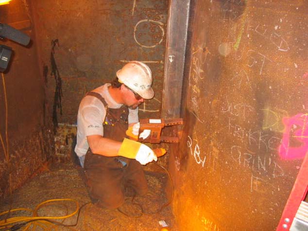 Figure 16: MTE inspector Mark Vasallo performing magnetic particle examination on pile head connection weld 2-B in Pier Footing Structure E4W.