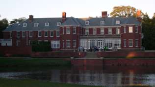 A photo of the Allerton Park Conference Center, a large red brick building, in Monticello, Illinois.