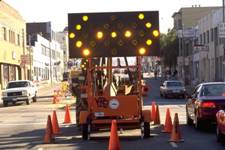 Photo of a lighted arrow traffic signal directing traffic around construction.