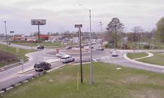 of a roundabout intersection with cars driving through it.